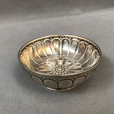 an antique silver plate with a flower design on it