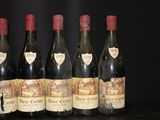 six bottles of wine are lined up in a row on a table