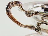 a silver cup with a spoon in it on a table