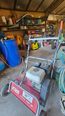 une photo d'un garage avec une tondeuse à gazon et d'autres outils