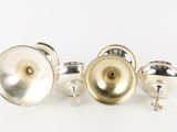 three silver plated objects on a white surface