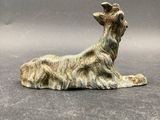 figurine of a dog laying down on a gray surface