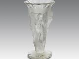 un vase en verre orné d'un ange, posé sur un socle