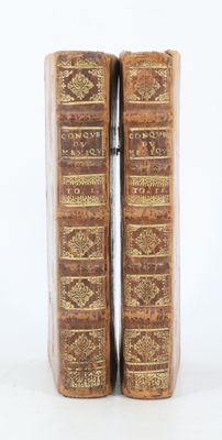 deux vieux livres posés l'un sur l'autre sur une surface blanche