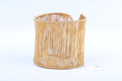 un gros plan d'un panier en bambou posé sur une surface blanche