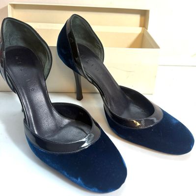 une paire de chaussures à talons hauts noires et bleues posées sur une boîte