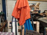 an orange umbrella hanging from a pole in a garage