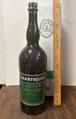une bouteille d'alcool posée sur une table à côté d'une règle