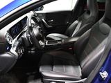the interior of a blue car with black leather seats and red stitching