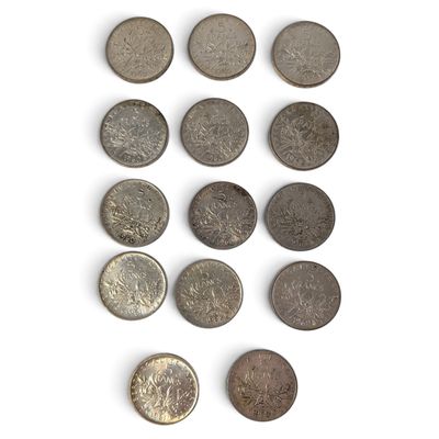 Plusieurs pièces différentes sont disposées en rangée sur une surface blanche