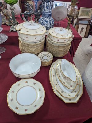 many plates and bowls sitting on a table with a red table cloth
