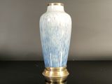 a blue and white vase sitting on a black table
