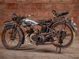 a old motorcycle that is parked in front of a brick wall