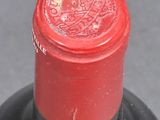 a close up of a bottle of wine with a red cap