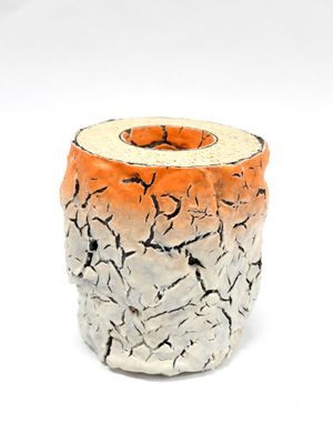 un vase blanc et orange dont la surface est craquelée
