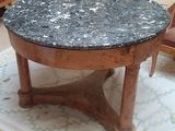 une table au plateau en marbre posée sur un tapis dans un salon