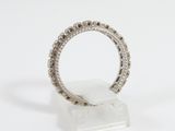 a close up of a diamond ring on a clear stand