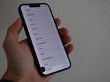 someone is holding a cell phone in their hand with a list on the screen
