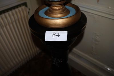 un vase bleu avec un socle doré posé sur une table