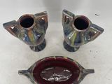 three pieces of pottery sitting on top of a white surface
