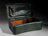 une boîte noire contenant un couteau, posée sur une table