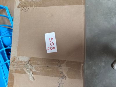 a cardboard box with a sticker on it sitting on the floor