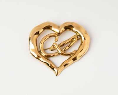 gold heart brooch with intertwined hearts on white background