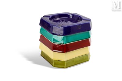des cendriers aux couleurs vives empilés les uns sur les autres sur une surface blanche