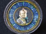 une photo d'une assiette bleue et dorée sur laquelle figure l'image d'un homme