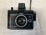 a polaroid camera sitting on a white surface
