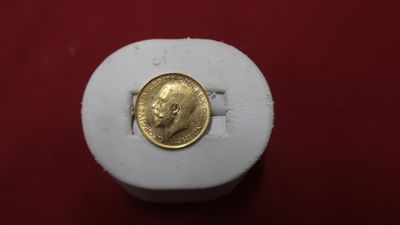 une image représentant une pièce d'or posée sur une boîte blanche
