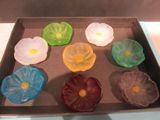 a box with six different colored glass flowers in it