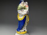 figurine représentant une femme en robe bleue tenant un éventail
