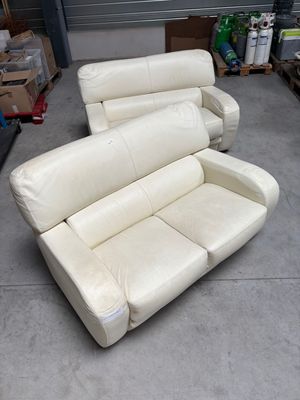 a white leather couch and a recliner in a garage