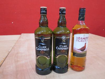 trois bouteilles d'alcool posées les unes à côté des autres sur une table