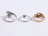 three gold and silver rings on a white surface