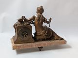 a statue of a woman sitting on top of a clock