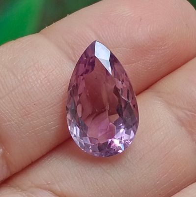 Quelqu'un tient dans sa main un très joli diamant rose.