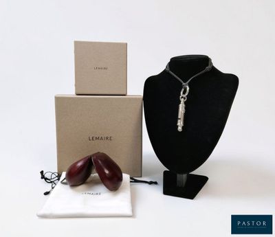 two necklaces on a mannequin with a box in the background