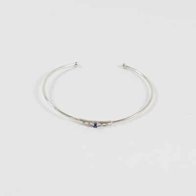 un gros plan d'un bracelet en argent orné d'une pierre bleue