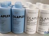 Quatre flacons d'Olaplex sont alignés sur un comptoir