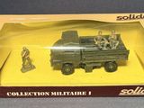 toy army vehicles are in a box on a gray surface