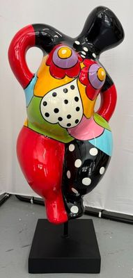 un vase coloré posé sur un socle noir