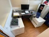 a desk with a computer monitor and a record player on it