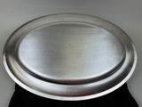 a silver plate on a black cloth on a table