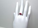 une main de mannequin blanche ornée d'une bague rouge