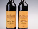 deux bouteilles de vin rouge posées l'une à côté de l'autre sur une table