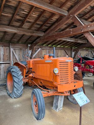 un tracteur garé dans une grange avec d'autres tracteurs