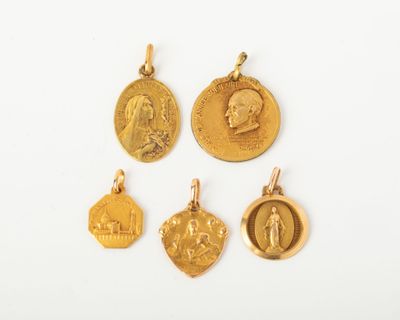 quatre médailles d'or sur lesquelles figurent l'image d'un homme et d'une femme