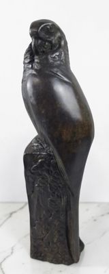 statue représentant un hibou perché sur une souche d'arbre posée sur une surface en marbre